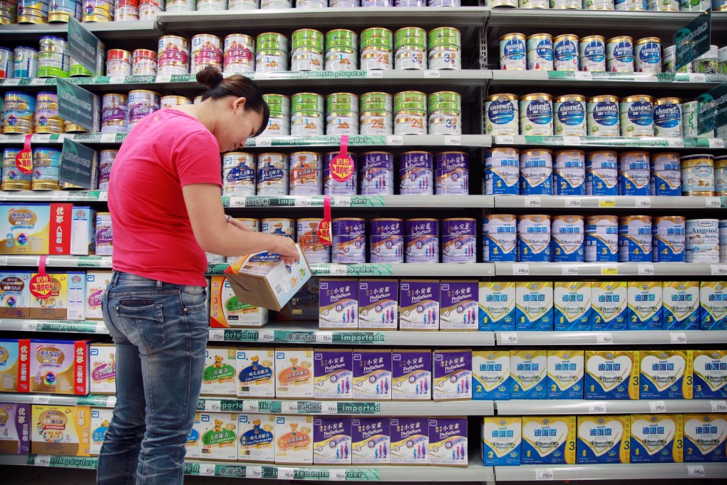 A woman checks out the label on baby milk powder in a supermarket in China. Photo: AFP