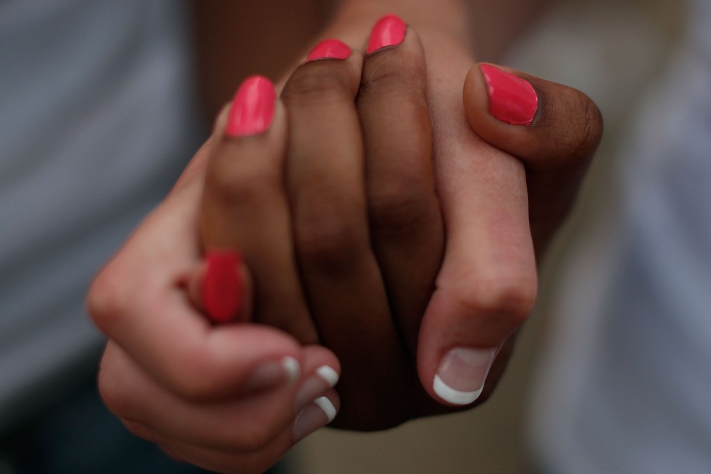 Students from the University of South Carolina and South Carolina State University link hands during a moment of silence for the victims of the church killings. Photo: AFP