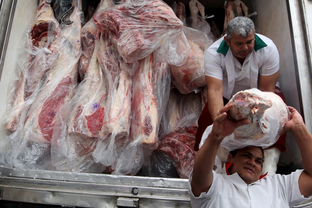 Workers unload packed meat from a truck in Sao Paulo. Photo: Reuters