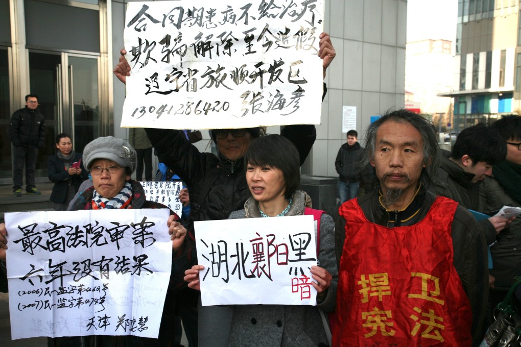 Supporters of the civil rights lawyer Xu Zhiyong protest outside the court in Beijing where he was tried for disturbing public order last year. He was later jailed for four years. Photo: EPA
