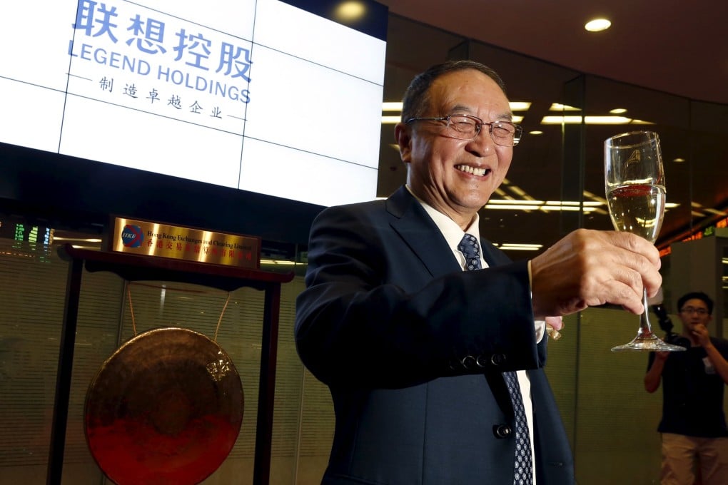 Liu Chuanzhi, chairman of Legend Holdings, poses in front of the logo of the company during the company's debut on the Hong Kong Stock Exchange. Photo: Reuters