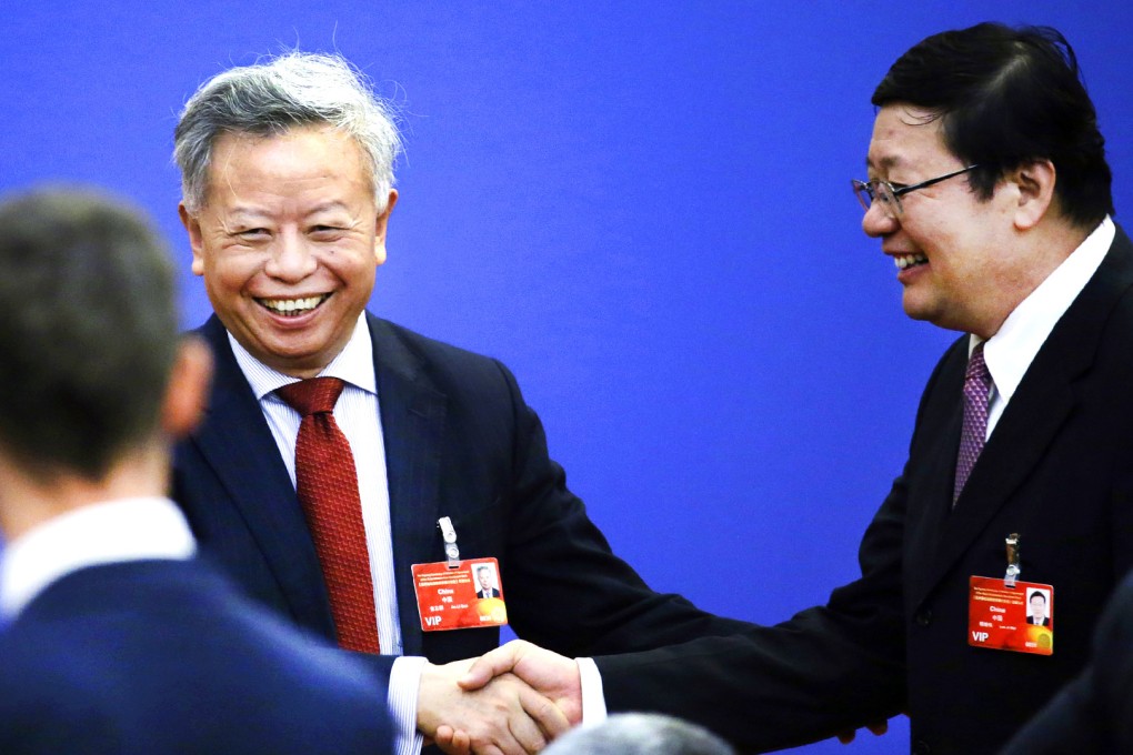 Jin Liqun (left), current secretary general of the Multilateral Interim Secretariat of Asian Infrastructure Investment Bank (AIIB), shakes hands with China's Finance Minister Lou Jiwei ahead of a signing ceremony of articles of agreement of the Asian Infrastructure Investment Bank (AIIB), at the Great Hall of the People in Beijing. Photo: Reuters
