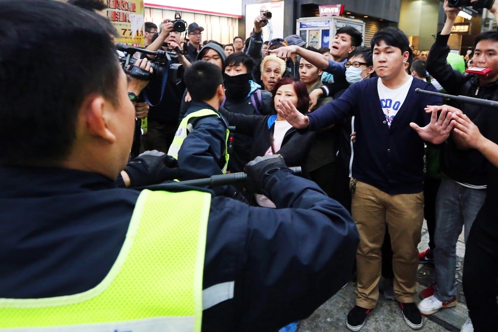 The defendant, Ng Lai-ying, used her chest to bump against the right arm of Chief Inspector Chan Ka-po as he dealt with her co-defendants during the chaotic protest in Yuen Long on March 1, 2015. Photo: Felix Wong