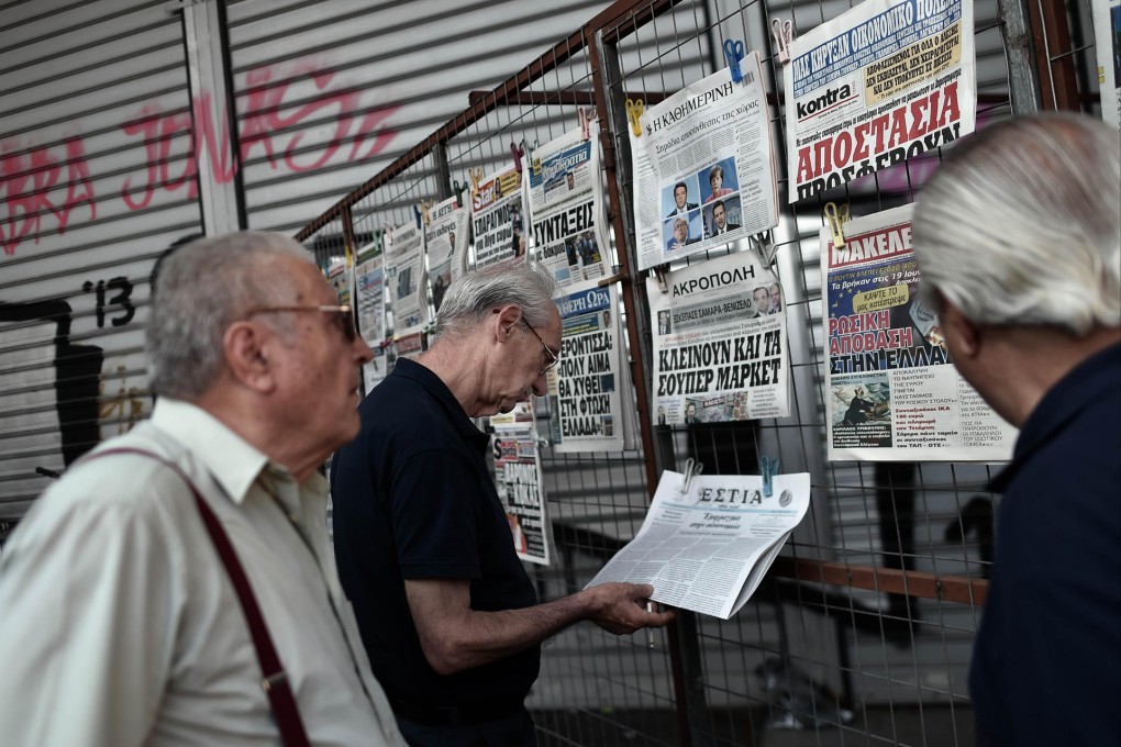 People read newspapers in central Athens on Tuesday as the country looked set to default on a loan to the IMF. Photo: AFP