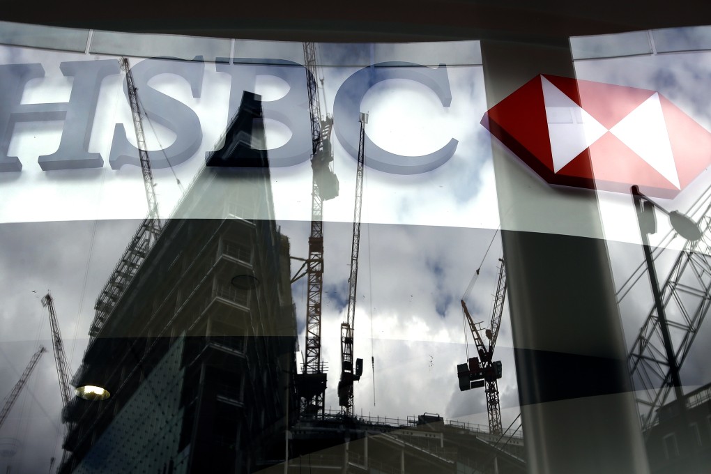 The HSBC logo is seen against the backdrop of a glass window showing the skyline of London. Photo: AP