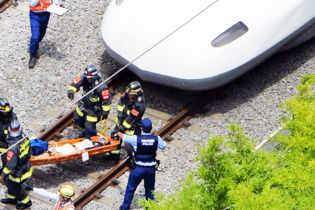 A passenger is carried by rescue workers from a Shinkansen bullet train after it made an emergency stop in Odawara, south of Tokyo. Photo: Kyodo