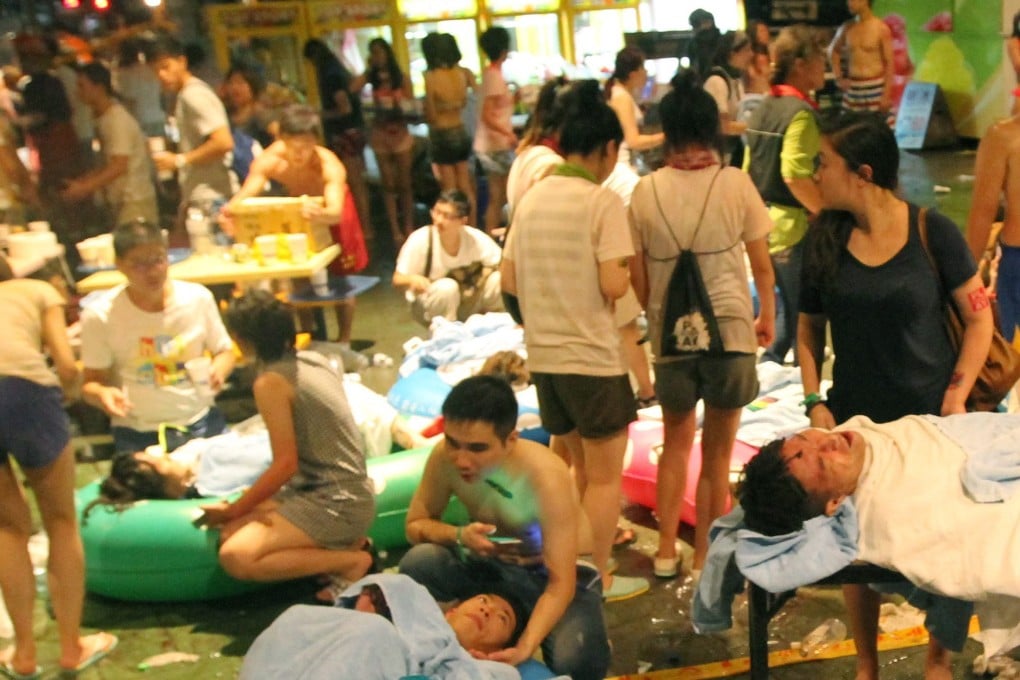 Taiwanese injured in a flash fire wait to be transferred to hospital at the Formosa Fun Coast park in Taiwan. Photo: EPA