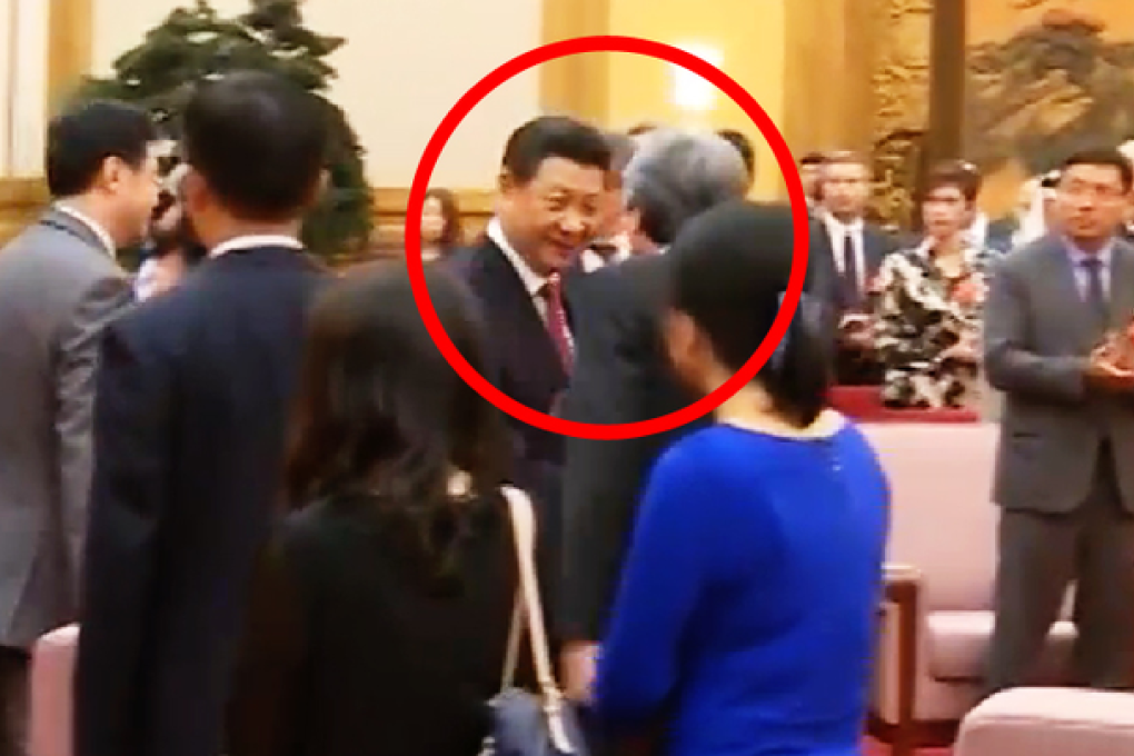 Television news footage shows Xi approaching Tsang at the start of a meeting yesterday. Photo: SCMP Pictures