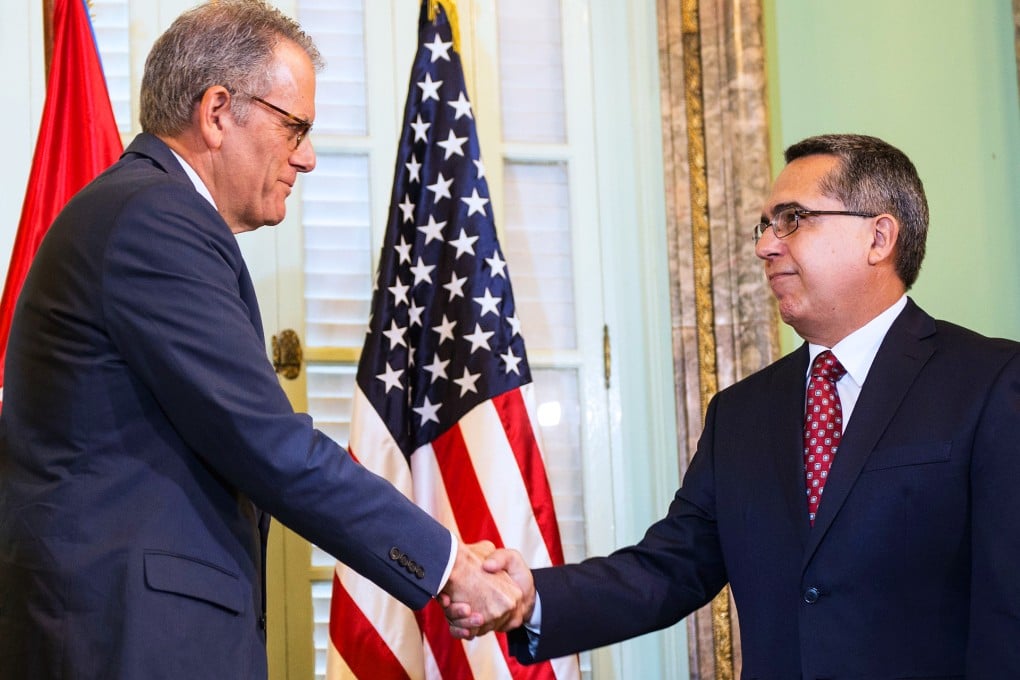 The head of US Interest Section, Jeffrey DeLaurentis (left) shakes hands with Cuban Foreign Vice-Minister Marcelino Medina after giving him a letter from US President Barack Obama to Cuban President Raul Castro, during a meeting at Foreign Ministry in Havana on July 1, 2015. Photo: AFP