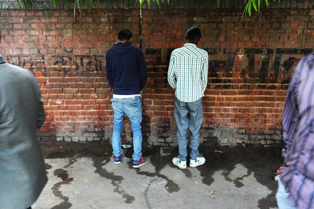 Indian men urinate on a wall at the roadside in New Delhi on the eve of World Toilet Day.  Photo: AFP