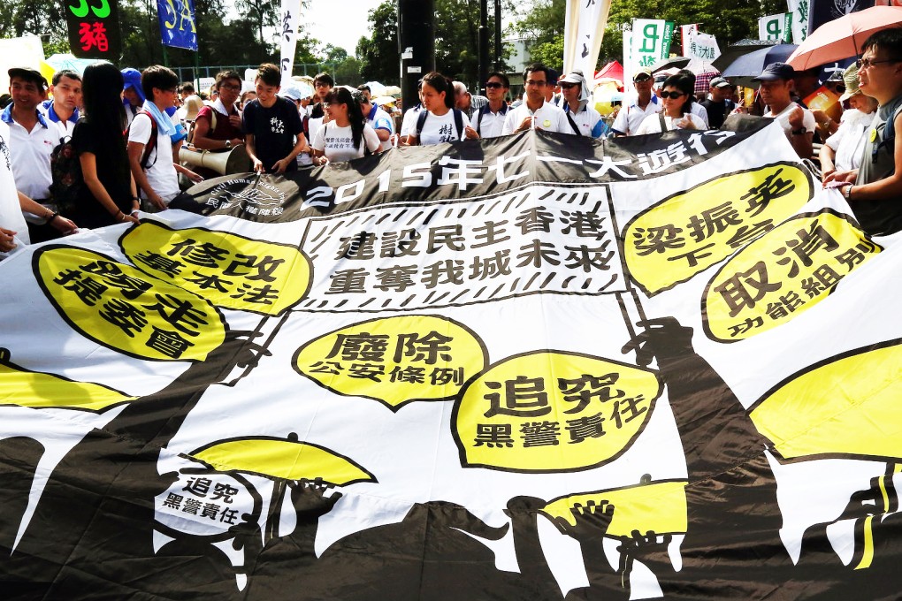 Pro-democracy activists in Victoria Park unfurl a flag outlining their five main demands before yesterday's protest march which featured a range of causes. Photo: May Tse