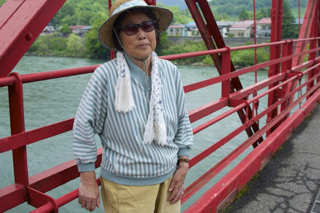 Fumiko Hatano, 79, stands on a bridge that spans the Agano River, into which mercury-laced effluent had been released. Photo: Rob Gilhooly