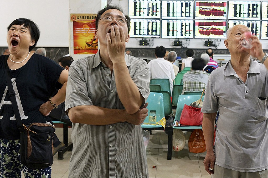 Investors watch computer screens showing stock information at a brokerage house in Wuhan. Photo: Reuters