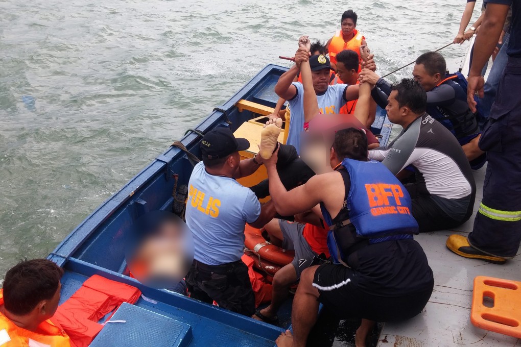 Filipino rescuers bring the bodies of two dead passengers to shore in Ormoc, Leyte, in this photo provided by the Philippine Coast Guard. Photo: EPA