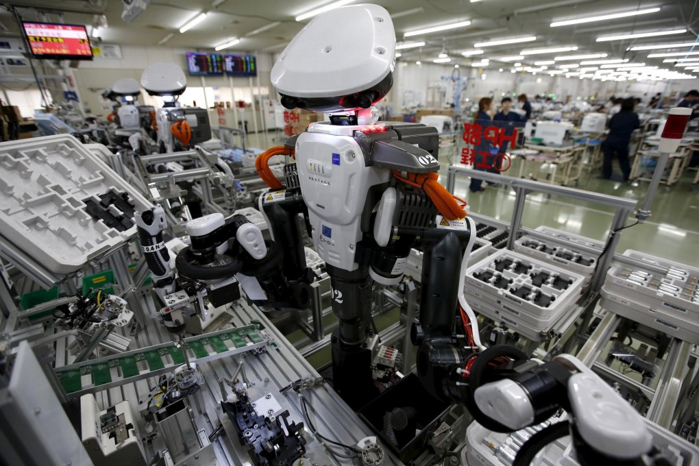 Robots work side by side with employees in the assembly line at Glory, a manufacturer of automatic change dispensers. Photo: Reuters
