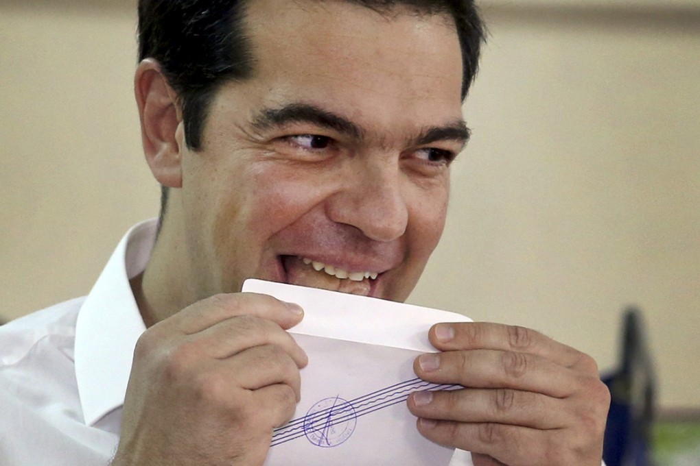 Greek Prime Minister Alexis Tsipras licks his ballot envelope before voting at a polling station in Athens. Photo: Reuters