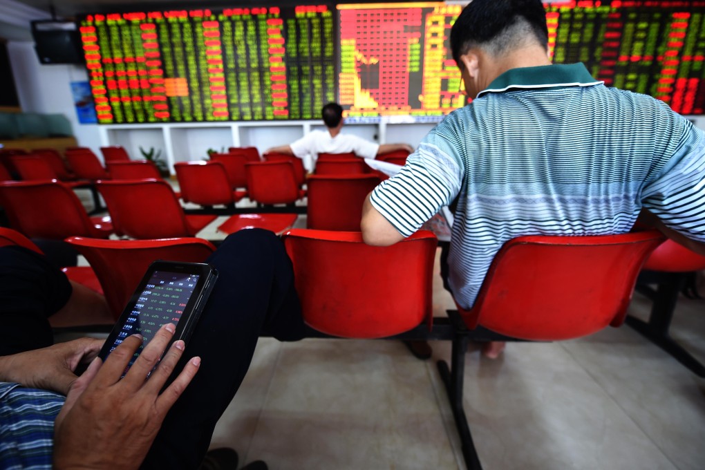 Chinese investors study stock prices in a securities firm in Haikou, Hainan province. Photo: Xinhua