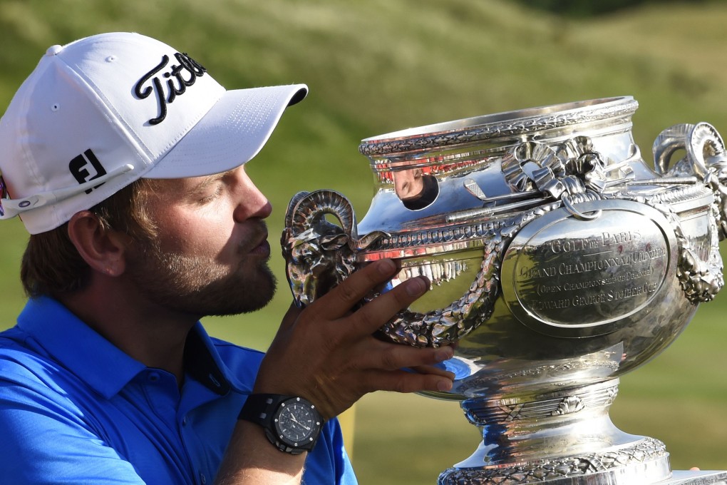 Bernd Wiesberger inspects the trophy. Photo: AFP