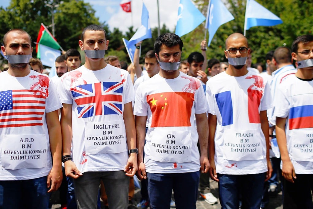 Uygurs living in Turkey and their supporters wear T-shirts with fake blood, representing Uygurs who have died in China. Photo: AP