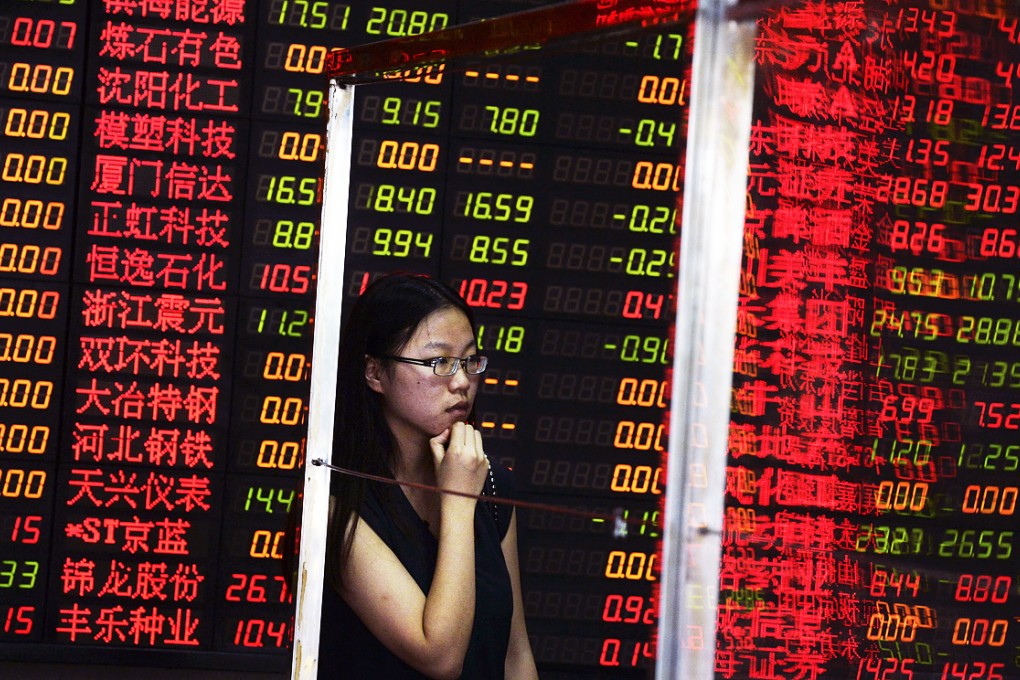 A woman studies stock prices at a brokerage house in Shanghai. The market there closed up 2.4 per cent on Monday. Photo: AP
