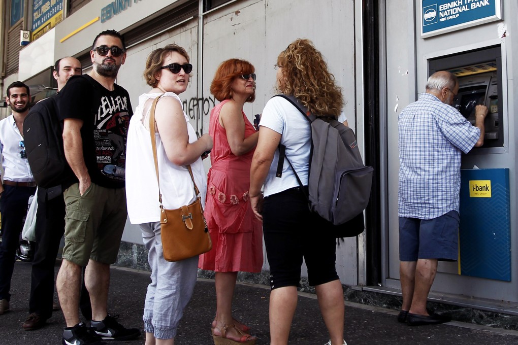 People queue to withdraw money from an ATM outside a branch of Greece's National Bank in Athens, Greece. Photo: EPA
