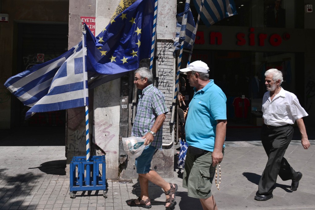 The flag of the European Union and Greece flutters in Athens as the value of the euro will take a hit in trying to resolve Greece's debt burden. Photo: AFP