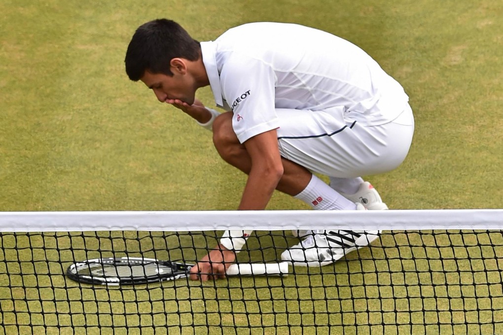 A relieved Novak Djokovic kisses the court after beating South Africa's Kevin Anderson yesterday in five sets. Photo: AFP