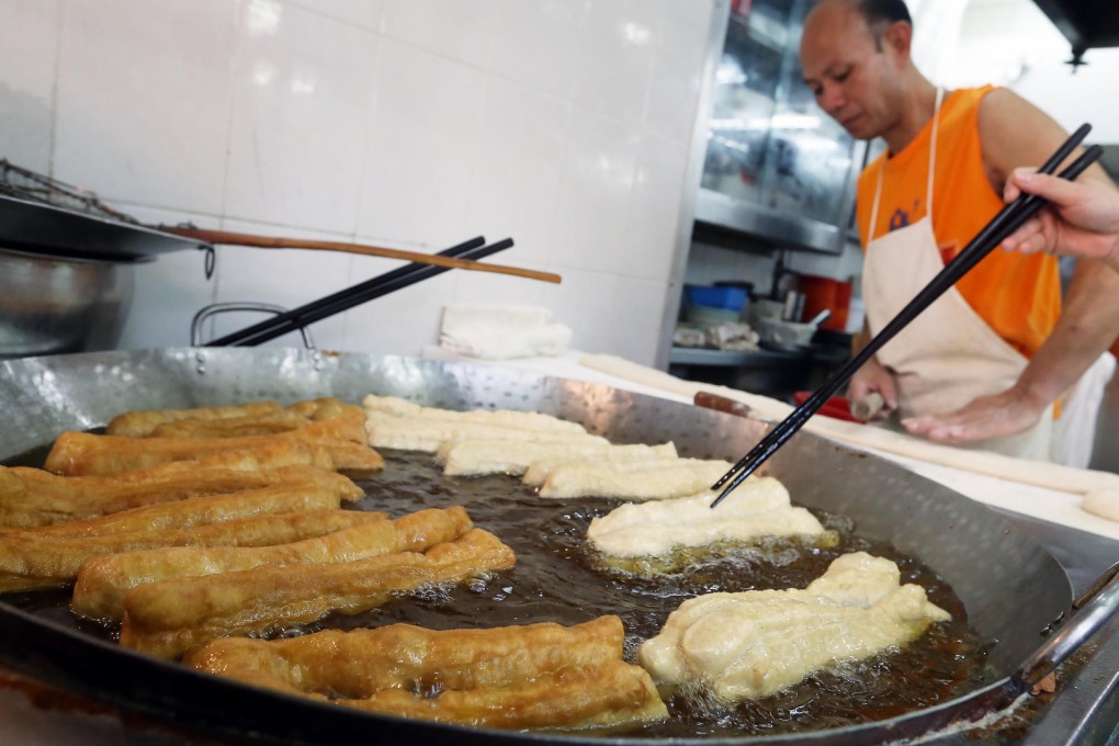 Mong Kok food vendor Tse Chi-keung, who prepares deep-fried breadsticks, will likely be affected by stricter laws now under public consultation. Photo: K. Y. Sheng