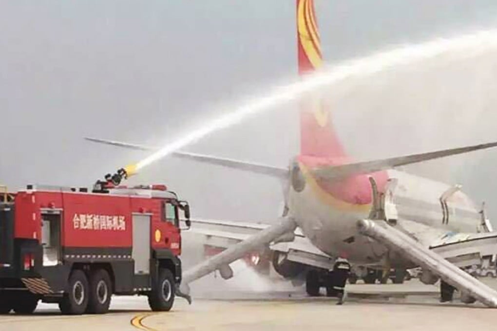 A fire engine hoses the Hainan Airlines jet after it returned to Hefei airport when a cargo bay fire alarm sounded. It proved to be a false alarm. Photo: Weibo