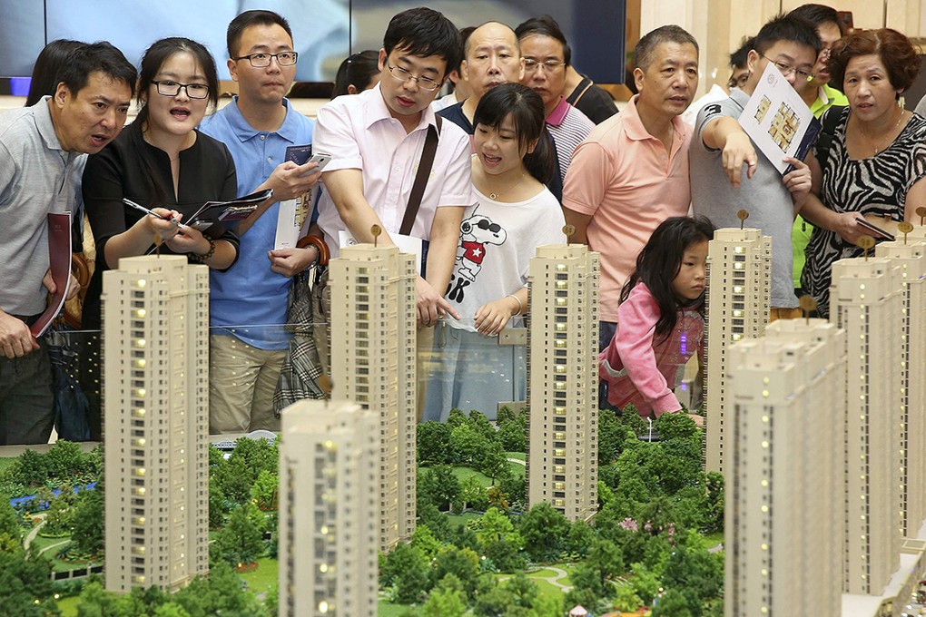 Potential buyers look at a model of a new residential compound at a branch of Longfor Properties in Hangzhou. Photo: Reuters
