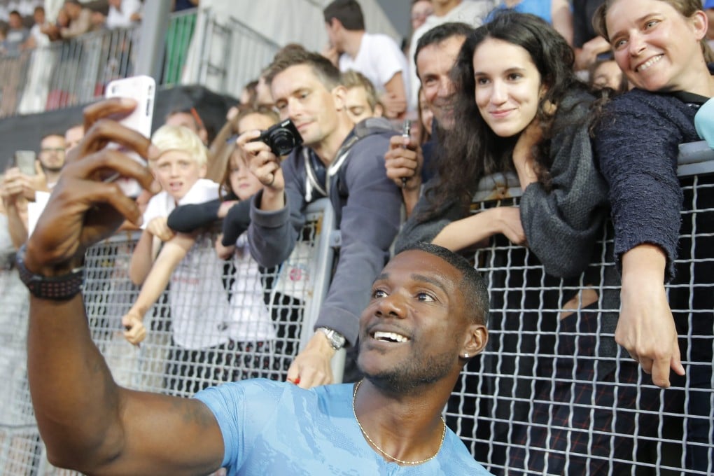 Justin Gatlin takes a selfie with fans. Photo: EPA