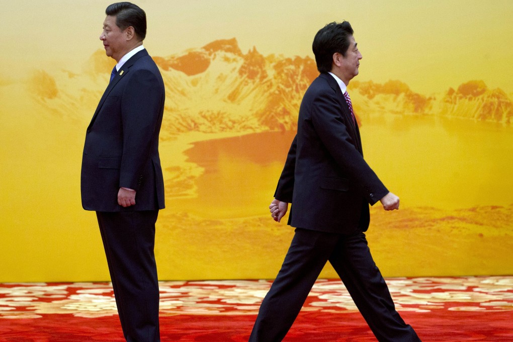 Japan's Prime Minister Shinzo Abe walks past Chinese President Xi Jinping during last year's Asia-Pacific Economic Cooperation summit at Beijing, China. Photo: AP