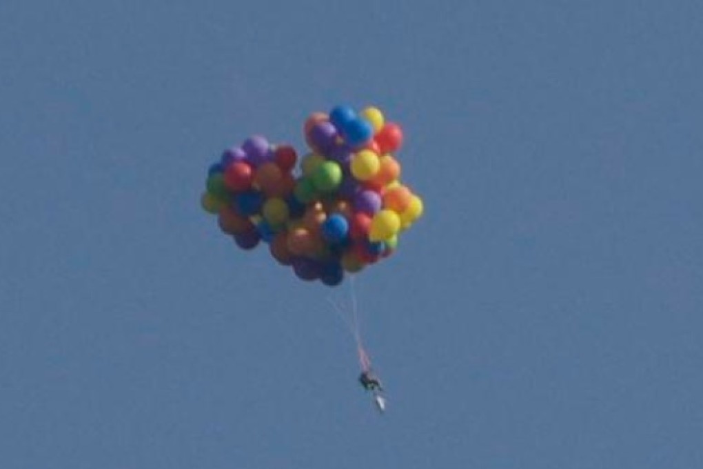 Up up and away... One brave Canadian takes to the sky in a balloon powered chair. Photo: SCMP Pictures