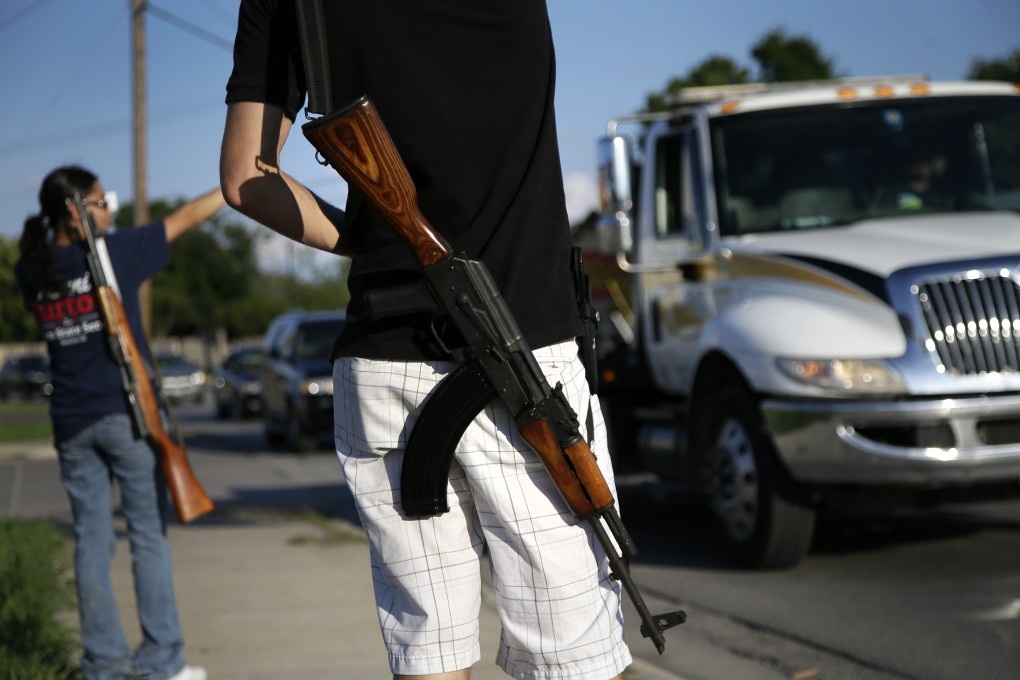 Texan Kory Watkins, armed with an AK-47 assault rifle, heads towards an "open carry" protest in Haltom City last year. Photo: AP