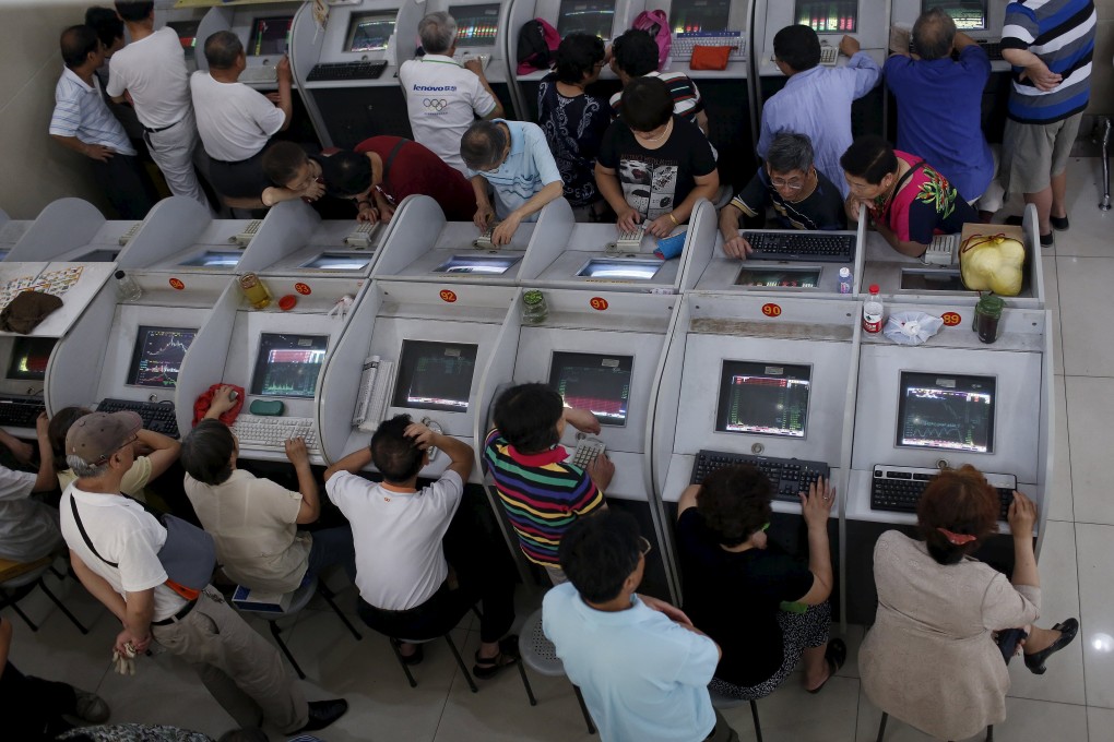Rows of investors pore over banks of computer screens to watch stock prices in Shanghai. Photo: Reuters