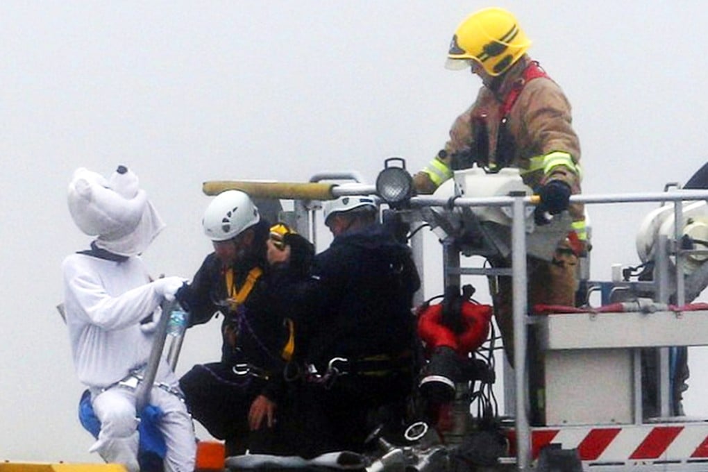 Emergency services at Heathrow Airport talk to an activist, dressed as a teddy bear, from the pressure group Plane Stupid. Photo: AP