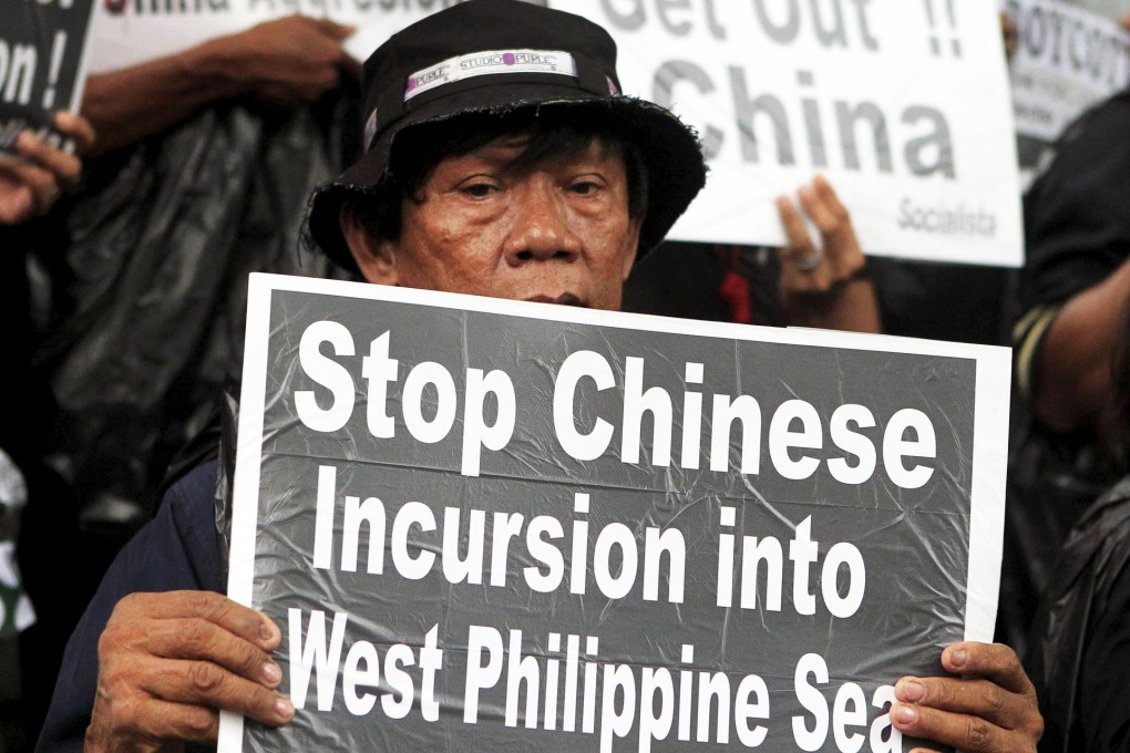 A protester holds a placard during a rally over the South China Sea disputes with China, outside the Chinese Consulate in Makati City, Metro on July 10, 2015.    Photo: Reuters
