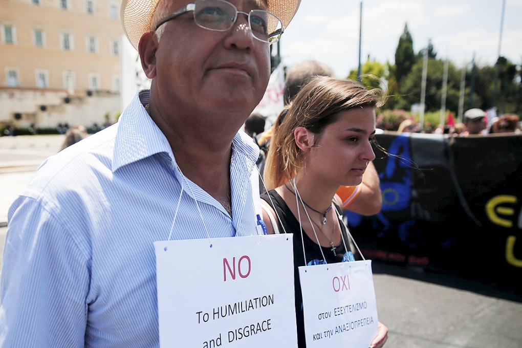 Protesters wear placards during a rally organised by the country's biggest public sector union marking a 24-hour strike in Athens. Photo: Reuters