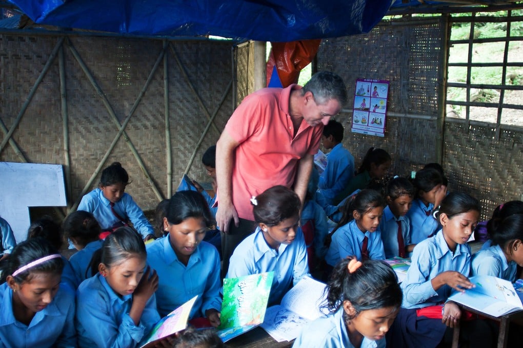 John Wood of Room to Read observes a class in the temporary learning centre in Shree Mandredhunga Primary School in Nuwakot. It is estimated that over one million children in Nepal's earthquake-affected regions are studying in such makeshift centres. Photo: Rishi Amatya/Room to Read