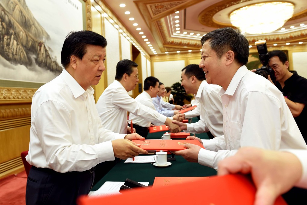 Politburo Standing Committee member Liu Yunshan (left) hands out an award to a county-level party secretary in Beijing last month. Many say cadres need to be subject to tougher discipline measures. Photo: Xinhua