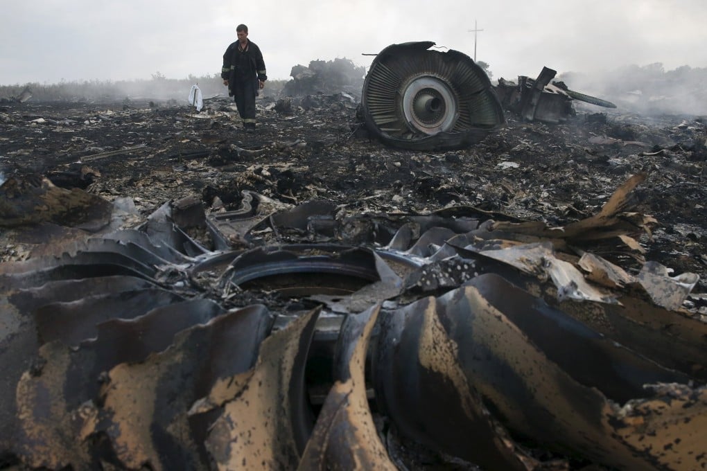 An emergency services worker walks at the crash site of flight MH17 near the settlement of Grabovo in the Donetsk region. The Malaysia Airlines plane was shot down on July 17, 2014 with 298 passengers on board. Photo: Reuters