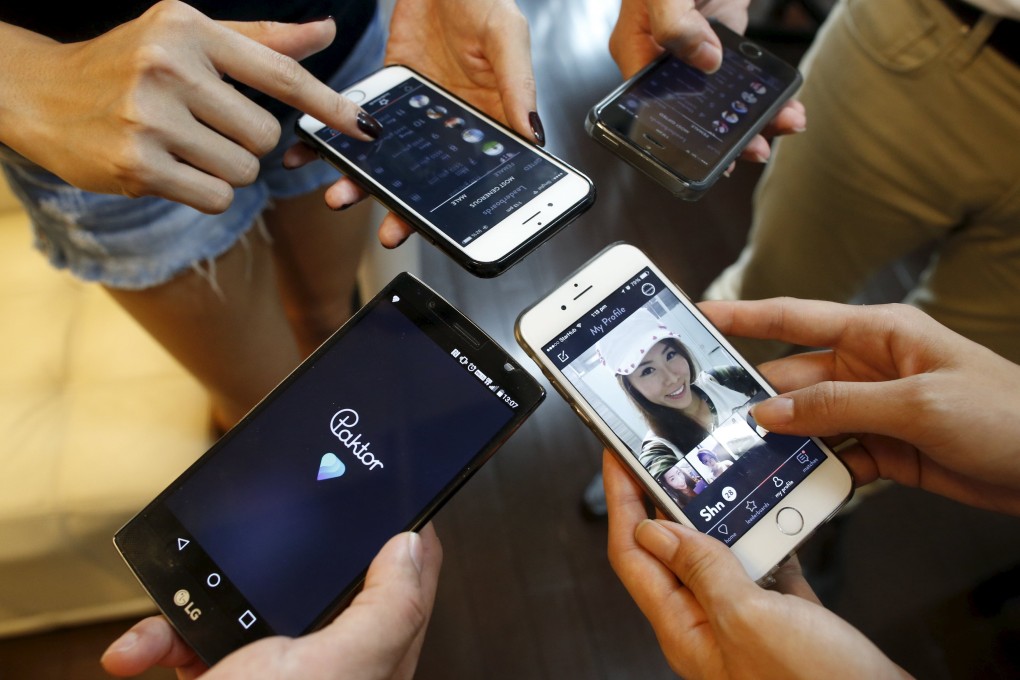 Paktor developers show their app in their office in Singapore. Photo: Reuters