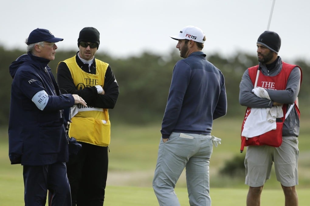 Dustin Johnson speaks with officials as play is suspended.Photo: AP