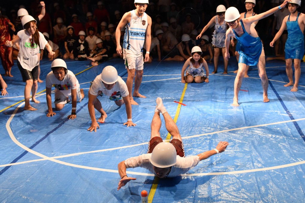 Contestants rush to catch a plastic bottle as they compete in an event during the 'Lube Olympics' in Tokyo on Saturday. Photo: AFP