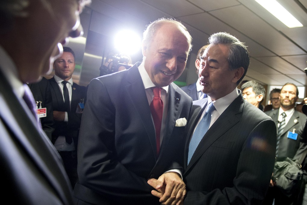 French Foreign Minister Laurent Fabius (left) chats to China's Wang Yi over Iran last week. Photo: AP