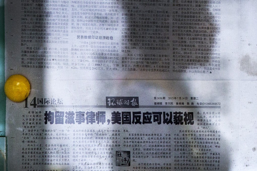 A woman walks past a Global Times editorial blasting the human rights laws as illegal activists and calling US condemnation of their arrest ''uncomfortable but inconsequential''. Photo: AP