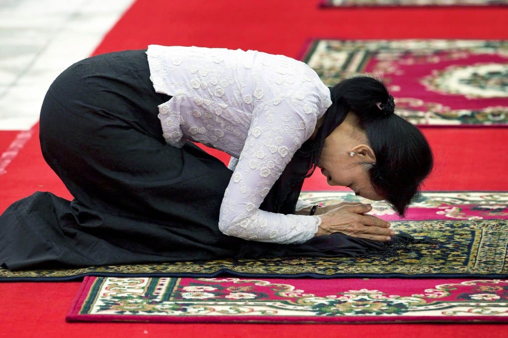 Myanmar opposition leader Aung San Suu Kyi pays respect at the tomb of her late father, Aung San, 68 years after his death. Photo: AP