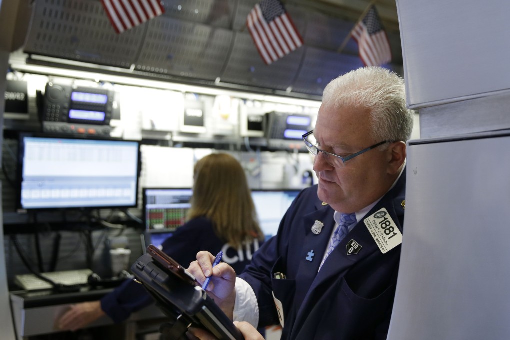 A broker on Wall Street works the floor of the stock exchange, with gold prices tumbling on Monday to its lowest in five years. Photo: AP