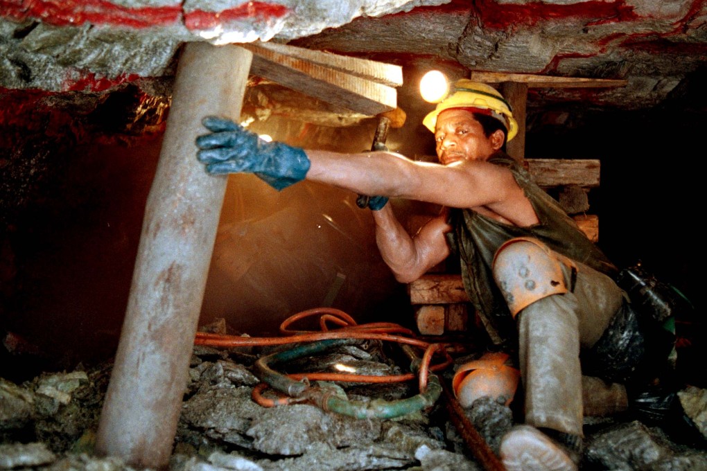 Workers at a gold mine in South Africa, as cost cutting in mines means the price of the metal may fall further after it sank on Monday to a five-year low. Photo: AP