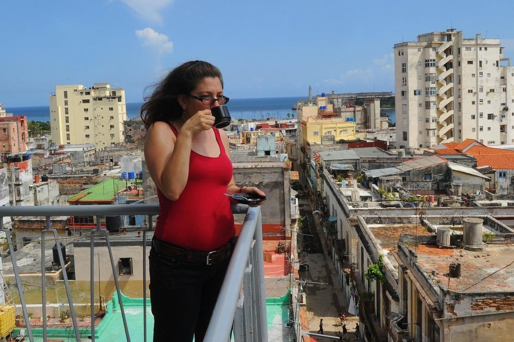 Airbnb has moved into Havana, Cuba, where this tourist enjoys the view with her coffee. Photo: AFP